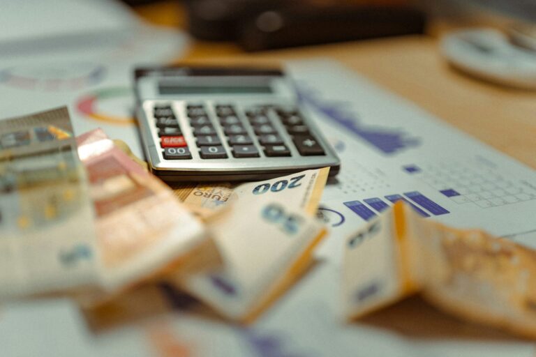 Calculator placed on a stack of cash for cash flow reporting