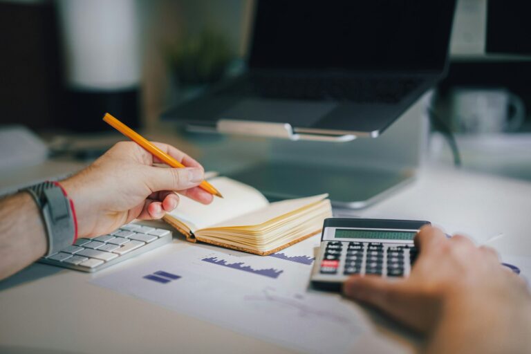 Calculator and notebook on desk for bank reconciliation