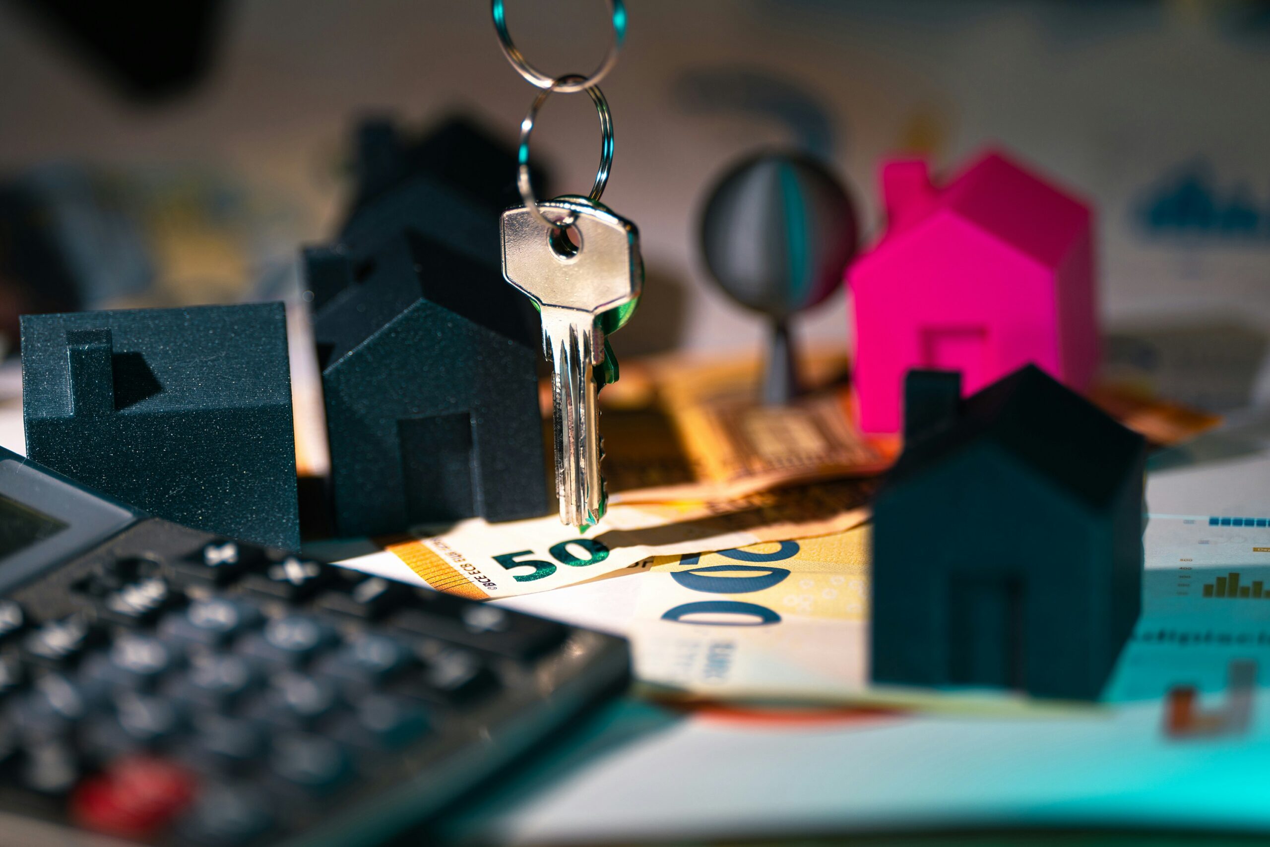 Calculator and house model representing a property management chart of accounts