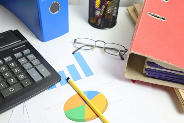 Desk with calculator and charts representing commercial property management accounting software