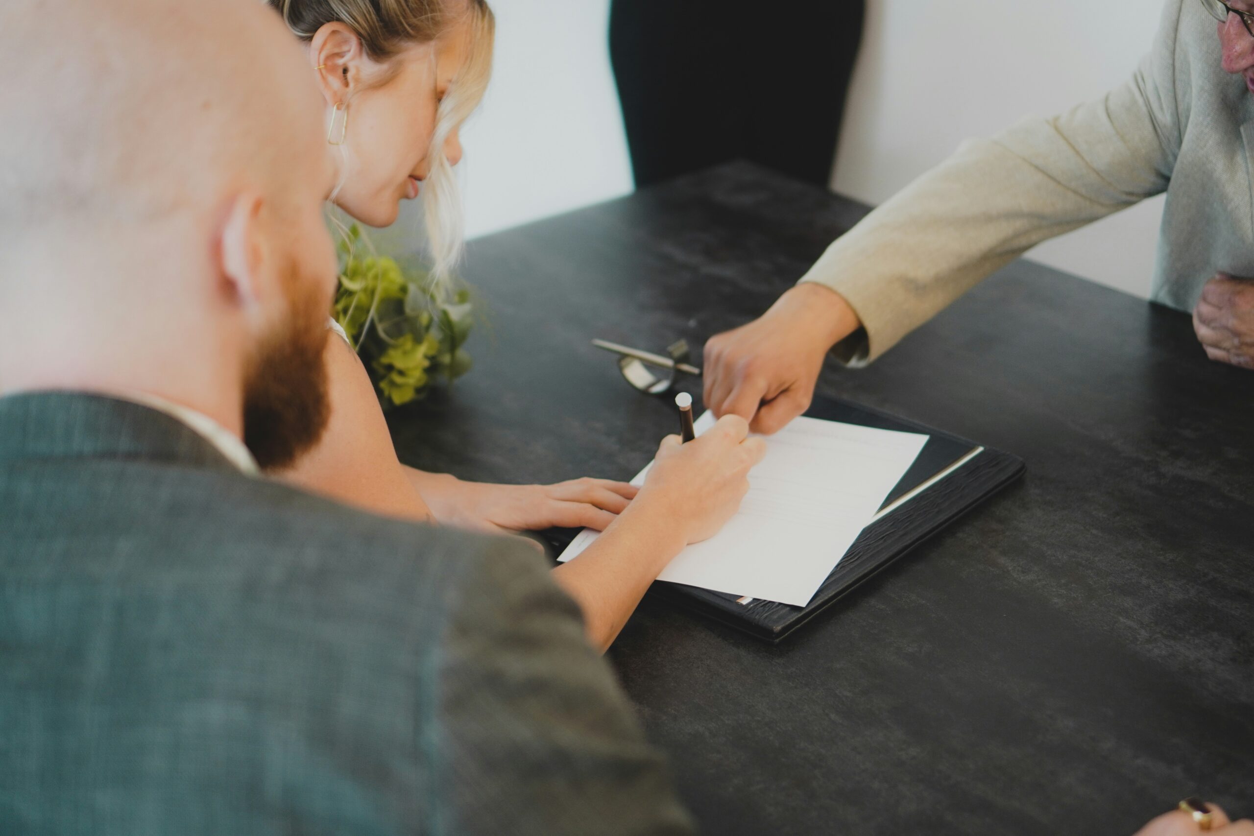 Couple signing a document representing commingling of funds property management prevention