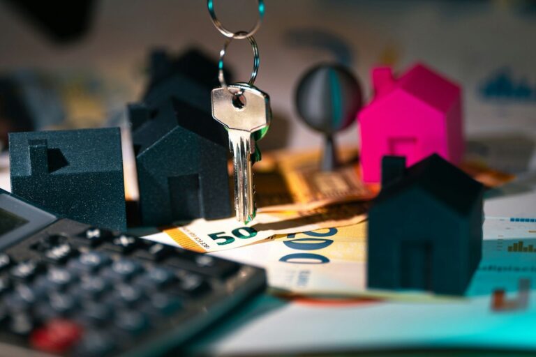 Calculator, house keys and a small house representing landlord insurance cost
