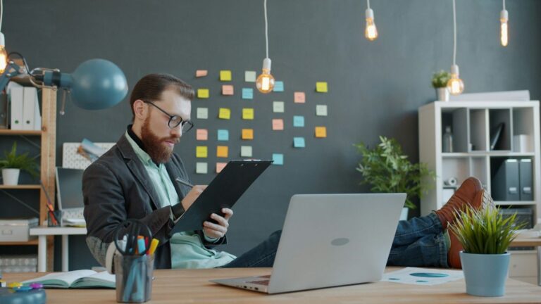Man with laptop and notes working on property management for Airbnb accounting