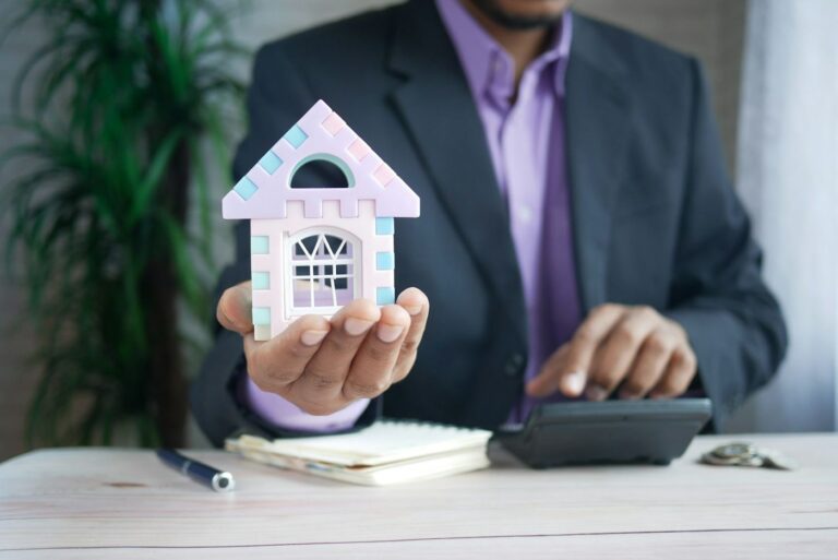 Model house next to a calculator illustrating rental property depreciation